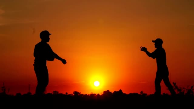 Silhouette-Baseball,-zwei-Männer-übten,-wie-sie-einen-Baseball-warfen-und-sich-trafen