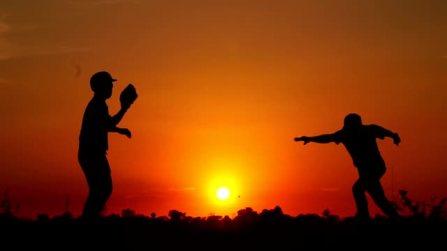 Silhouette-baseball,-two-men-were-practicing-throwing-a-baseball-and-getting-together