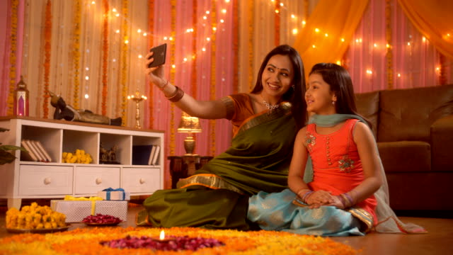 Ocasión-del-festival---joven-madre-india-está-haciendo-clic-en-un-selfie-con-su-hija.-Decoración-Diwali