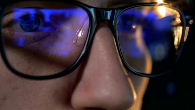 Close-up-of-glasses-put-on-a-man-with-a-computer-game-reflecting-in-them