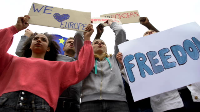 Activistas-cantan-eslogan-sosteniendo-carteles-para-que-no-haya-fronteras-en-la-UE-y-crisis-migratoria