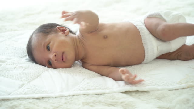 4K-Breite-Aufnahme-von-entspannenden-schlafenden-kleinen-asiatischen-Neugeborenen-Junge-Sohn-trägt-Windel-auf-weißem-Bett-im-Schlafzimmer-zu-Hause-liegen-und-gähnen.-Unschuldige-Neugeborene-Gesundheitsversorgung-und-empfindliche-Haut-Konzept.