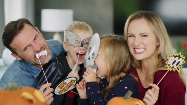 Porträt-der-verspielten-Familie-mit-Masken-während-Halloween