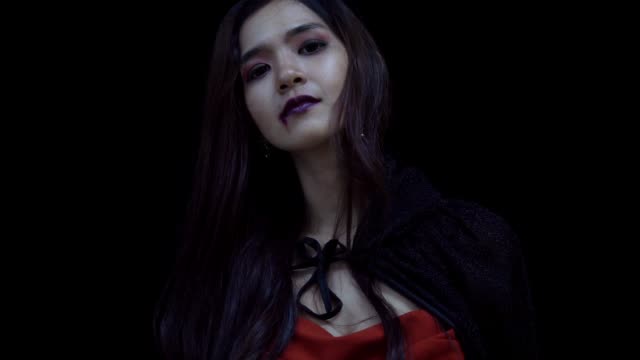 Mujer-asiática-en-bruja-Halloween-traje-de-apertura-bufanda-de-la-cabeza-negra-y-mirando-a-la-cámara,-en-cámara-lenta