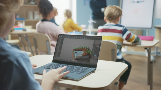 Grundschule-Informatik-Klassenzimmer:-Über-die-Schulter-Ansicht-eines-Kindes-mit-Laptop-zu-entwerfen-3D-Spiel,-Aufbau-Ebene-in-strategischen-Rollenspiel-Videospiel