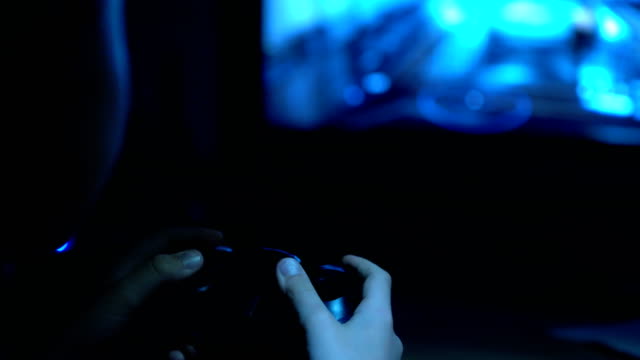 4K-poorly-lit-footage-of-boy-holding-joystick-in-hand