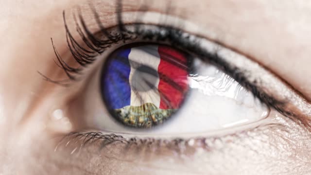 mujer-ojo-verde-en-primer-plano-con-la-bandera-de-Francia-en-el-iris-con-el-movimiento-del-viento.-concepto-de-vídeo