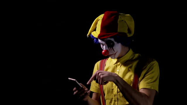 A-clown-uses-a-smartphone-to-call-the-viewer.