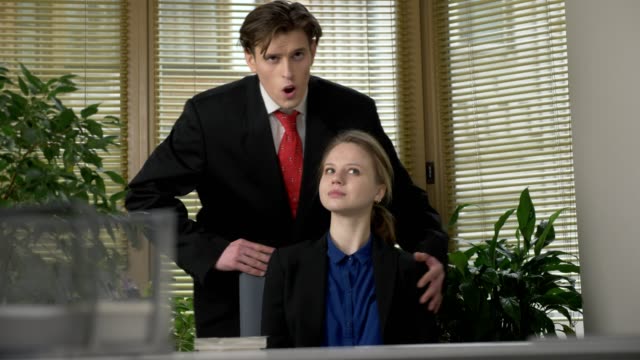young-guy-in-a-suit-flirts-with-his-employee,-enthusiastically-tells-her-the-story,-gestures-with-his-hands.-Work-in-the-office-concept.-Presentation-60-fps