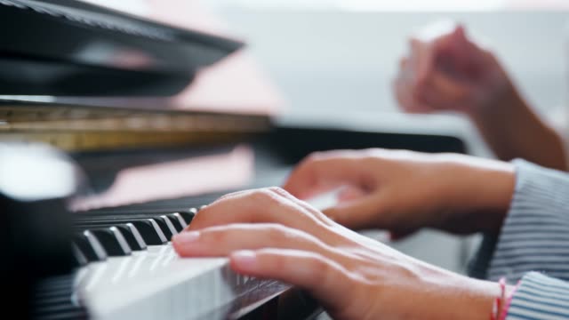 Cerca-de-la-pupila-con-el-maestro-tocando-el-Piano-en-la-lección-de-música