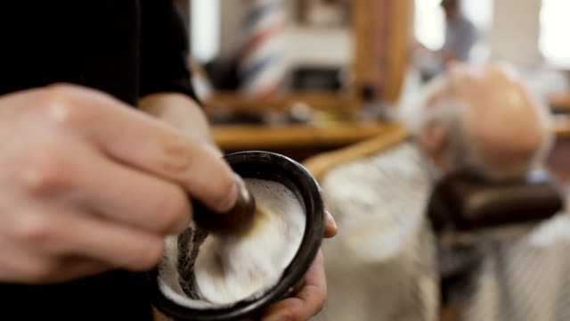 Estilista-mezcla-crema-de-afeitar-con-brocha