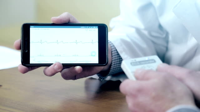 A-Doctor-demonstrates-a-cardiogram-on-the-mobile-phone