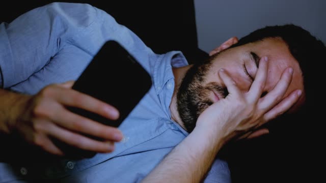 Ein-trauriger-Mann-schlechte-Nachrichten-auf-Handy-lesen