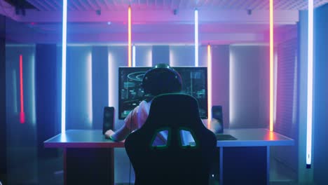 Professional-Gamer-Playing-and-Winning-in-First-Person-Shooter-Online-Video-Game-on-His-Personal-Computer.-Footage-Fade-out-into-Bokeh.-Room-Lit-by-Neon-Lights-in-Retro-Arcade-Style.-Cyber-Sport-Championship.