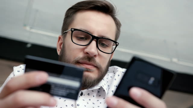 Man-using-online-banking-with-smart-phone-and-card