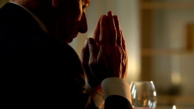 Senior-woman-beten-am-Tisch-vor-dem-festlichen-Abendessen,-Erinnerung-an-Frau-verstorben