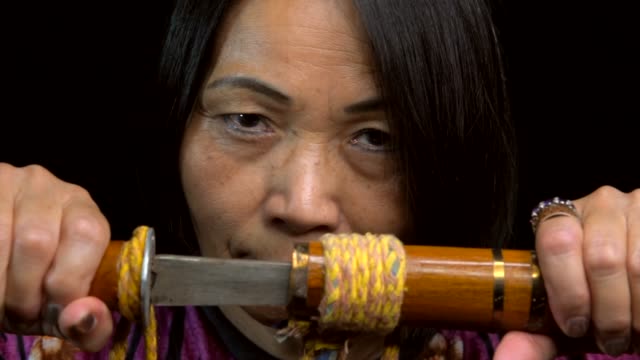 primer-plano-de-la-antigua-espada-de-apertura-mujer-asiática