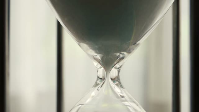 Time-Lapse-of-hourglass-clock-sand-dropping-close-up-shot---Time-speed-moving-fast-with-blinking-daylight