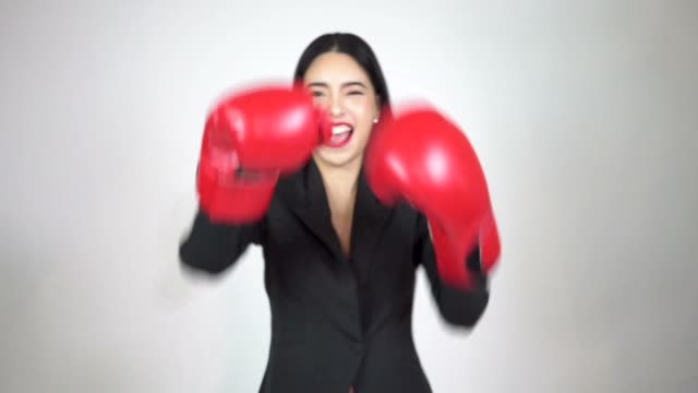 Young-happy-and-energetic-business-woman-keeps-punching-and-raising-hands-with-boxing-gloves-on-white-background