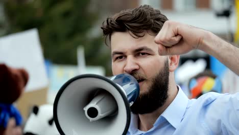 Young-adult-man-shouts-in-megaphone.-Caucasian-people-shout-violently-and-angry.