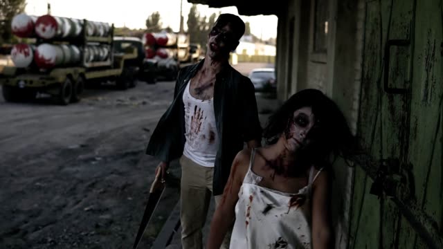 Halloween-Horror-Filmen-Konzept.-Bild-gruselig-männlichen-und-weiblichen-Geist-oder-Zombie-zu-Fuß-mit-Verwundeten-Gesicht-und-blutige-Kleidung.-Industrielle,-verlassene-Stadt-und-Spuren-auf-dem-Hintergrund