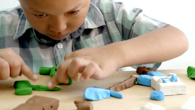 Child's-hands-playing-colorful-clay-on-table.-Development-of-fine-motor-skills-of-fingers-and-creativity,-education