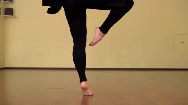 Close-up-of-female-contemporary-dancer-legs-choreography-making-pirouettes-in-slow-motion