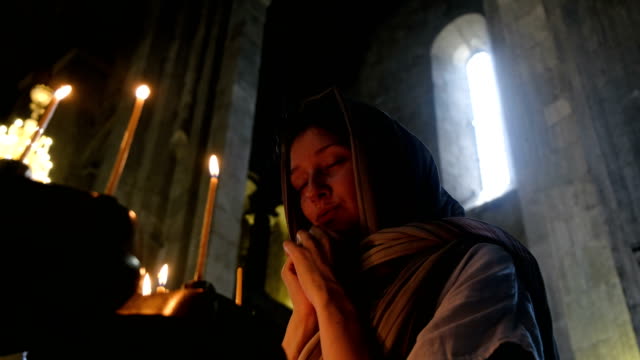 Frau-in-ein-Kopftuch-vor-einer-Ikone-in-der-orthodoxen-katholischen-Kirche-beten