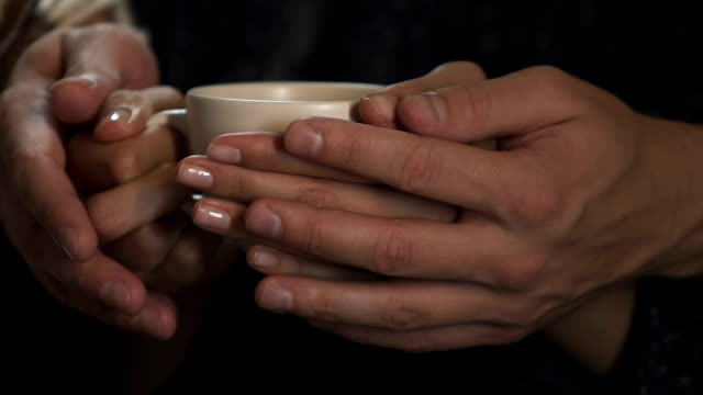 Macho-y-hembra-las-manos-sostener-taza-de-café-caliente,-cuidando-a-amado