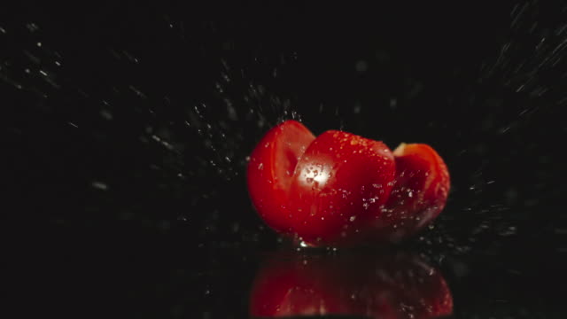 SLOW-MOTION:-Tomato-falls-on-a-table-and-pieces-scatters-in-different-directions