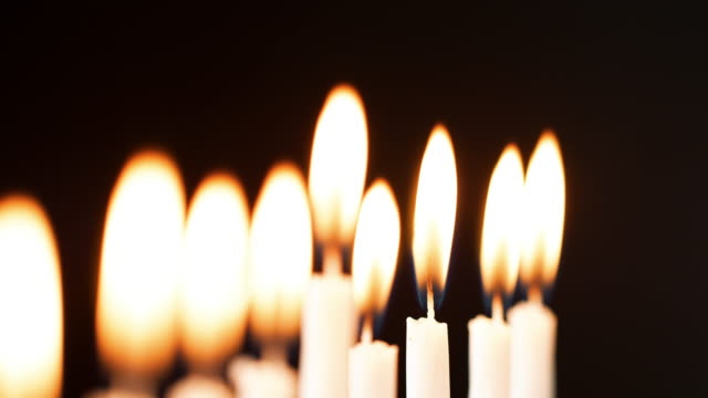 Rack-Fokus-Detail-Aufnahme-der-Flammen-auf-eine-Reihe-von-neun-weißen-Kerzen-brennen-am-jüdischen-Feiertag-von-Hanukkah