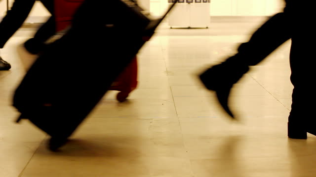 Beine-von-Passanten-mit-tragen-auf-Gepäck-am-Flughafen-terminal