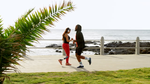 Couple-jogging-at-promenade-on-a-sunny-day-4k