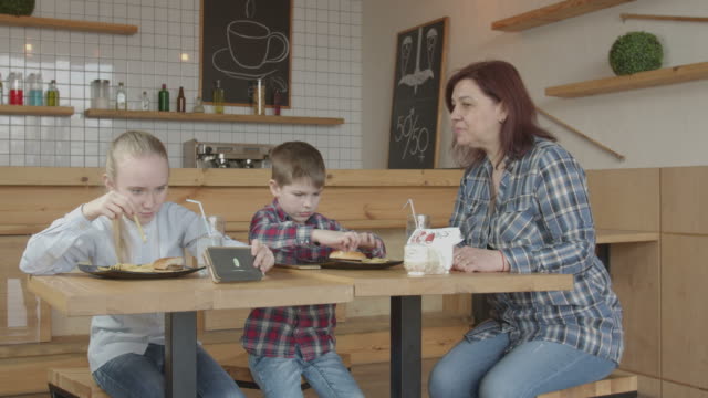 Babysitter-forbidding-kids-gaming-phones-in-cafe