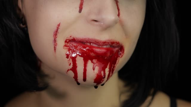 Blutiger-Mund-und-Zähne-des-Mädchens.-Vampir-Halloween-Make-up-mit-tropfendem-Blut