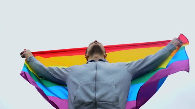 El-hombre-levanta-la-bandera-del-arco-iris,-marcha-por-la-derecha-LGBT,-la-solidaridad-con-el-matrimonio-entre-personas-del-mismo-sexo