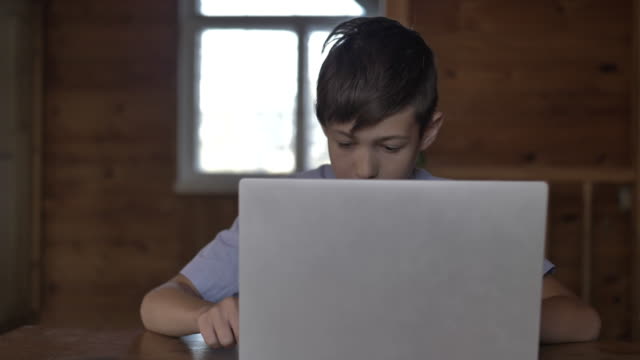 lustige-Junge-sitzt-am-Tisch-und-tippt-auf-einem-Laptop-sehr-schnell,-Hacking