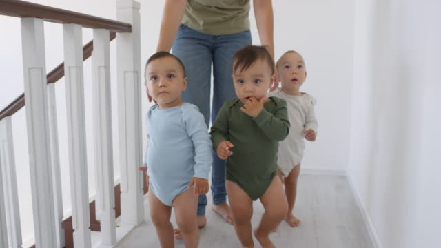 Asian-Toddler-Walking-at-Home-and-Siblings-Following