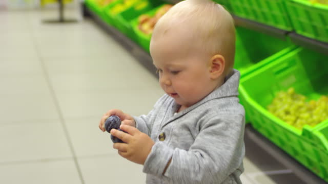 Cute-Toddler-Taking-Plums-at-Supermarket