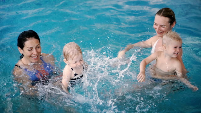 Schwimmbad.-Mütter-bringen-kleinen-Kindern-das-Schwimmen-bei.