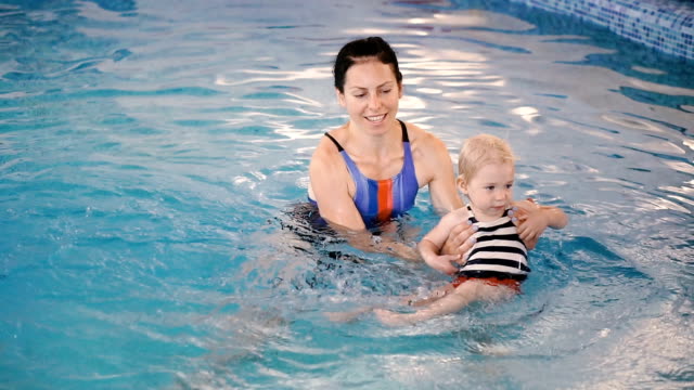 Piscina.-Mamá-le-enseña-a-un-niño-pequeño-a-nadar-en-la-piscina.