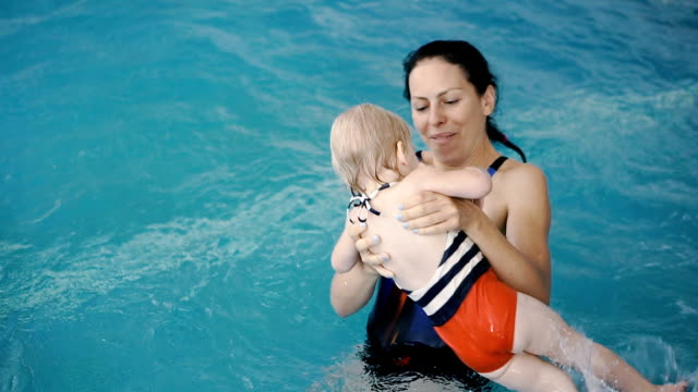 Swimming-pool.-Mom-teaches-a-young-child-to-swim-in-the-pool.