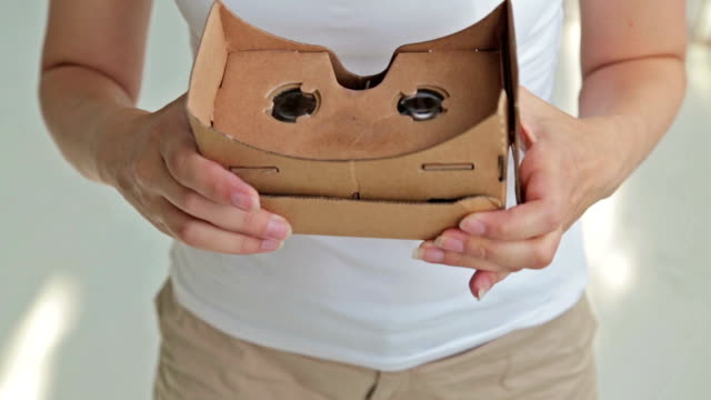Joven-mujer-rizada-utilizando-gafas-de-realidad-Virtual.-Cartón-de-Google