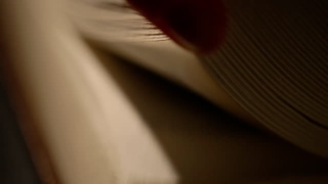 Hand-leafing-through-an-old-book-pages