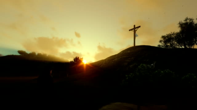 Woman-praying-at-Jesus-cross-against-beautiful-sunrise,-panning