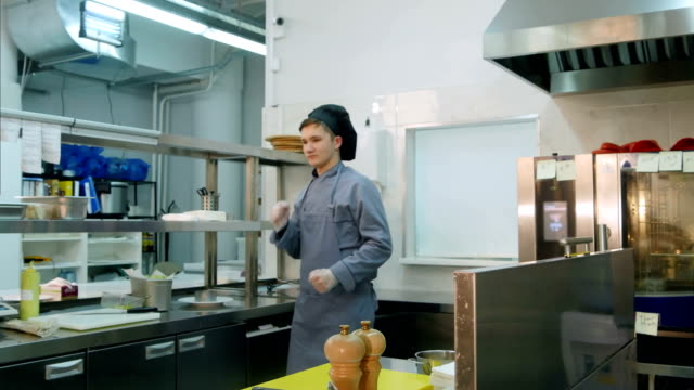 Funny-young-male-cook-dancing-in-the-professional-kitchen