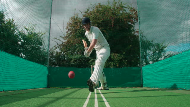 Un-jugador-haciendo-práctica-red-pega-a-la-pelota-de-cricket.