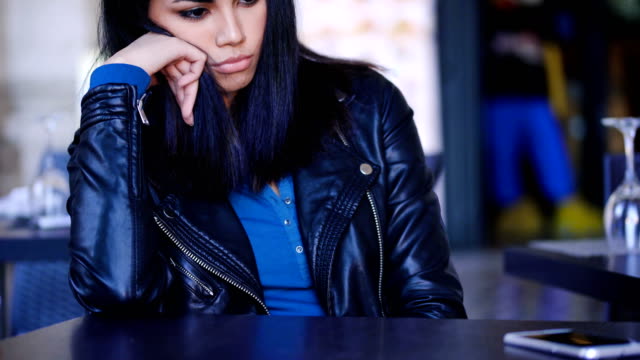 Mujer-asiática-triste-y-pensativa-sentado-en-bar-al-aire-libre