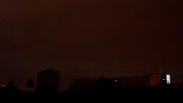 view-from-the-window-to-the-stormy-sky.-night-outside,-outside-the-window-dressed-with-rains-and-lightning-flashed.-seen-from-the-window-high-houses-FullHD