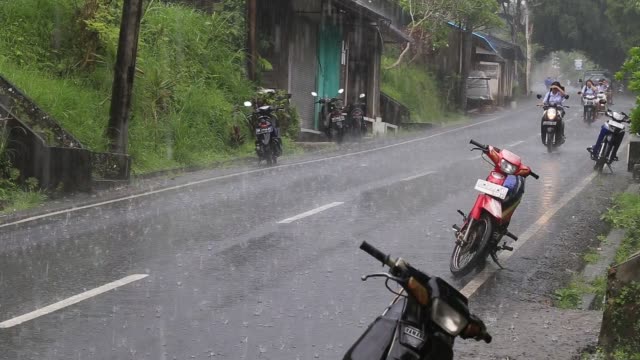 Traffic-along-a-typical-street-on-the-road-during-the-rain-in-Ubud,--Bali,-Indonesia